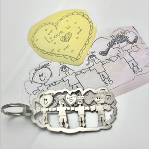 Detailed family drawing by kids transformed by hand into a key chain in durable titanium