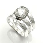3 band silver ring with platinum half bezel set with larger diamond