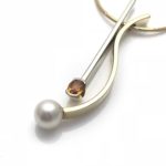 Oval yellow sapphire in white gold paired with yellow gold cultured pearl pendant