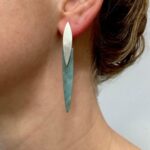 Earrings on ear with green stone