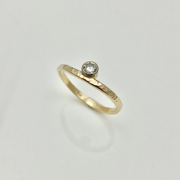 Gold stack ring with bezel set diamond, curved and hammered band